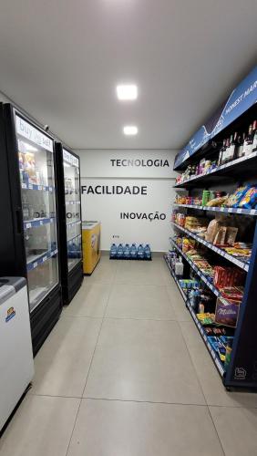 an aisle of a store with a refrigerator and drinks at Apartamento 5 estrelas próximo ao Shopping e USP in Bauru