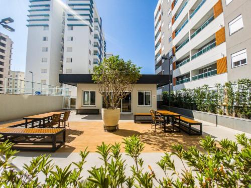 a patio with tables and chairs and buildings at Apartamento 5 estrelas próximo ao Shopping e USP in Bauru