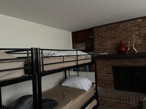 a room with two bunk beds and a fireplace at Sunny and Spacious, Hottub, Piano, Guitars, Fenced Yard, Pets Welcome, LGBT Friendly in Westminster