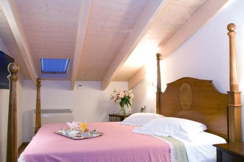 1 dormitorio con 1 cama con manta rosa en Arhontiko Pepos, en Nafpaktos