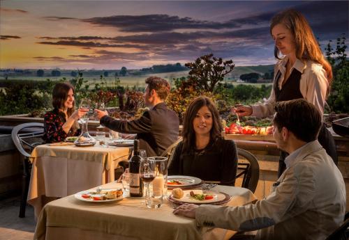a group of people sitting at a table in a restaurant at Agriturismo Valle del Marta in Tarquinia