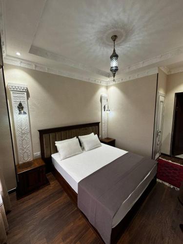 a bedroom with a large bed with white sheets at Altair Boutique in Samarkand