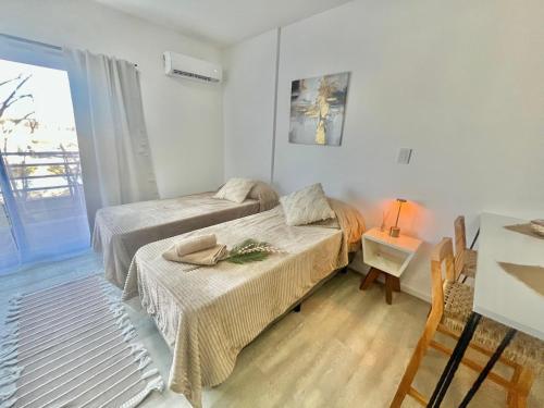 a bedroom with two beds and a table with a lamp at L&M Suite Monoambiente in Belén de Escobar