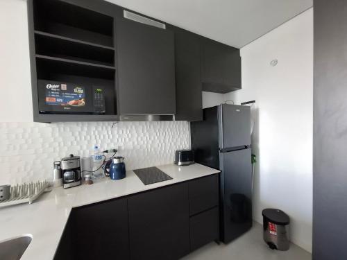 a kitchen with black cabinets and a refrigerator at Apartment Tower Luxury Home Palace a 100 mts Shopping del Sol con parking amplio in Asuncion