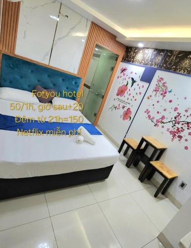 a hotel room with a bed and two tables at For You Hotel in Ho Chi Minh City