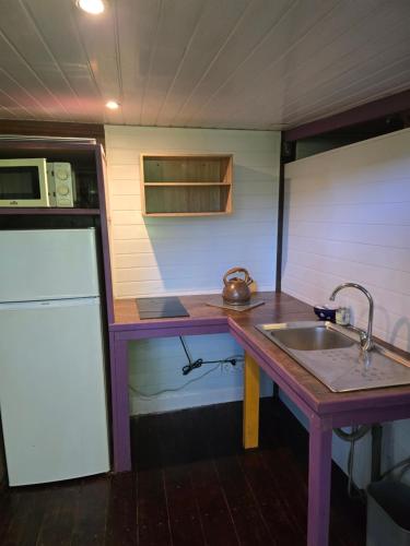 a small kitchen with a sink and a counter at Gîte et meublés du Tour du monde in Dumbéa