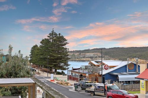 a street in a town with a tree and a body of water at Port Central No 3 in Port Campbell
