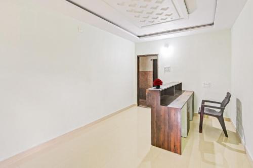 a chair in a room with a white wall at Hotel O VRK Residency in Visakhapatnam