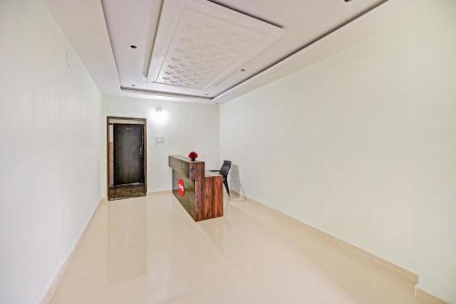 a white walled room with a table and a chair at Hotel O VRK Residency in Visakhapatnam