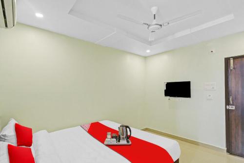 a room with a bed and a tv on the wall at Hotel O VRK Residency in Visakhapatnam