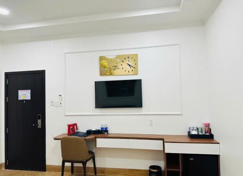 a room with a desk and a tv on the wall at khách sạn yên châu 2 in Chau Doc