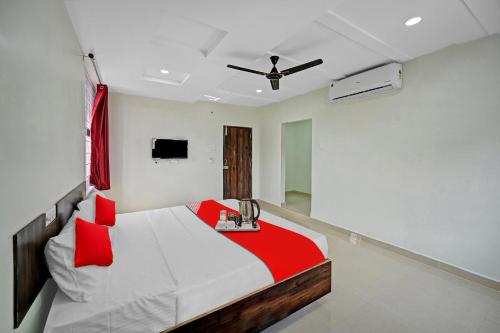 a bedroom with a bed and a ceiling fan at Hotel O VRK Residency in Visakhapatnam
