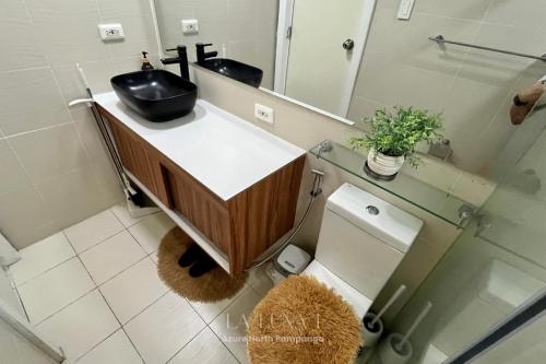 a bathroom with a sink and a toilet and a mirror at Studio for Couples with Mt Arayat View with Netflix, Karaoke & Boardgames in San Fernando