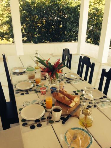 a table with a breakfast of bread and orange juice at Villa Noria in Las Terrenas