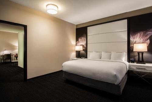 a hotel room with a large bed and a mirror at TRYP by Wyndham Savannah in Savannah