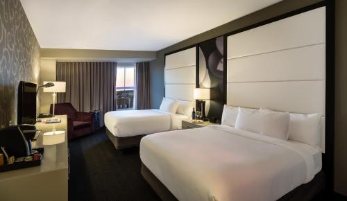 a hotel room with two beds and a television at TRYP by Wyndham Savannah in Savannah