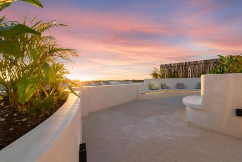 a patio with a view of the ocean at sunset at Luxury Jungle Condos by Casago in Tulum