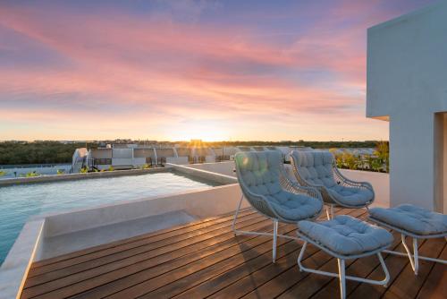 a deck with two chairs and a swimming pool at Luxury Jungle Condos by Casago in Tulum