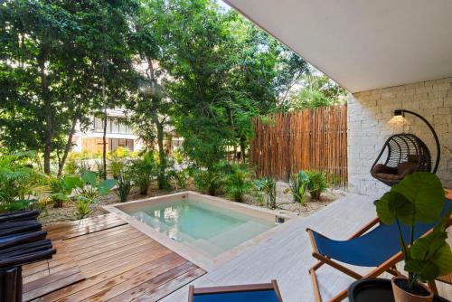 a swimming pool in the middle of a patio with a fence at Luxury Jungle Condos by Casago in Tulum