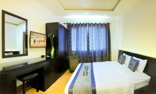 a bedroom with a bed and a vanity and a mirror at Panda Hotel in Ho Chi Minh City