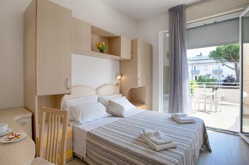 1 dormitorio con 1 cama con toallas en B&B Hotel Serenità, en Bellaria-Igea Marina