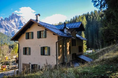 une maison avec un toit solaire au sommet d'une colline dans l'établissement Ostello SanMartino, à San Martino di Castrozza