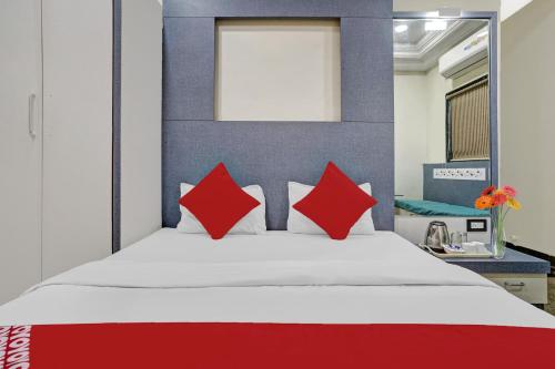a bedroom with a large bed with red pillows at Hotel O Chhaya in Aurangabad