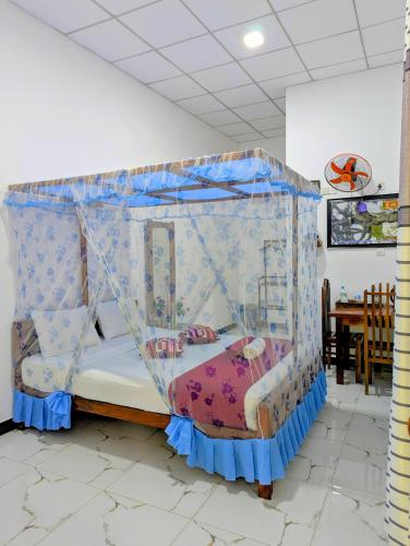a bed with a canopy in a room at Nehansa Resort and safari in Tissamaharama