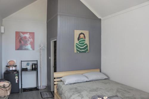 a bedroom with a bed and paintings on the wall at Grace Riverfront in Lat Krabang