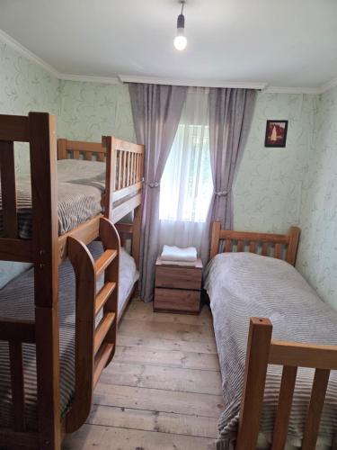 a bedroom with two bunk beds and a window at Chvibiani Guesthouse & Bar in Ushguli