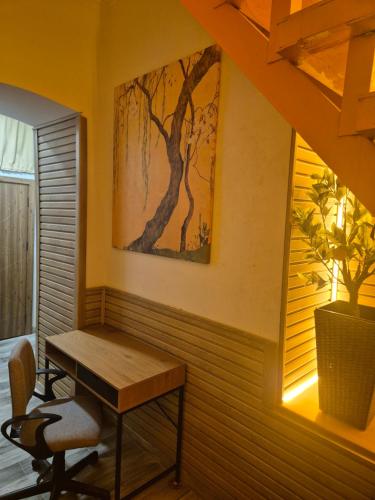 a table and chairs in a room with a painting on the wall at Orange House, City-Center Stay in Tbilisi City