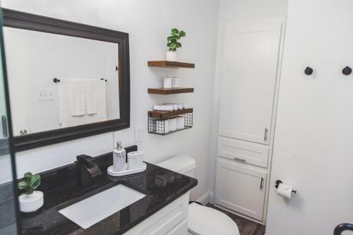 un bagno con lavandino, specchio e WC di Chic Comfort Restful Escape a Fort Worth