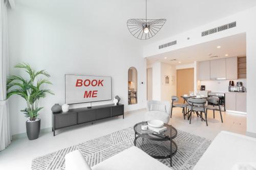 a living room with a book me sign on the wall at Free housekeeping visits during your stay - StayShort - Creek Harbour Sleeps 4 Perfect for Nature Lovers in Dubai