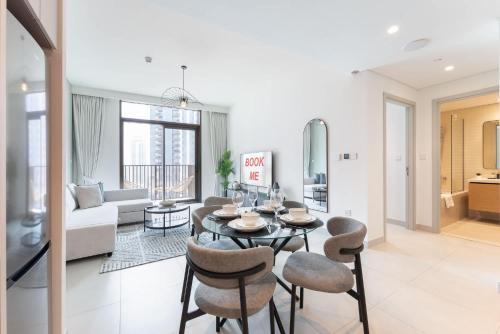 a living room with a table and chairs at Free housekeeping visits during your stay - StayShort - Creek Harbour Sleeps 4 Perfect for Nature Lovers in Dubai