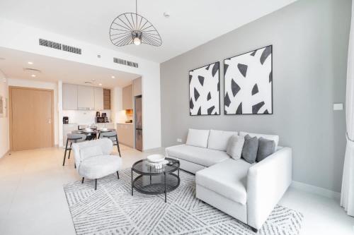 a living room with a couch and a table at Free housekeeping visits during your stay - StayShort - Creek Harbour Sleeps 4 Perfect for Nature Lovers in Dubai