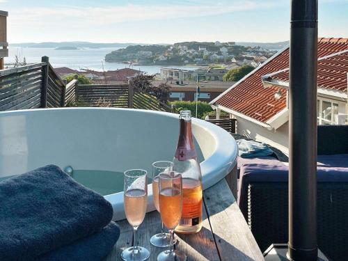 Ellösにある8 person holiday home in ELLÖSのバスタブの横のテーブルにシャンパン1本とグラスを用意しています。
