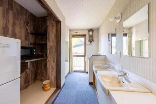 a bathroom with two sinks and a mirror at マウンテンサイド大竹 in Nozawa Onsen