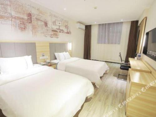 a hotel room with two beds and a tv at City Comfort Inn Changsha Window of the World Zhongmao City in Changsha