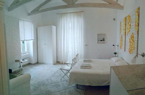 a white room with a bed and a chair at La Torre e il Mare Rooms in Monopoli