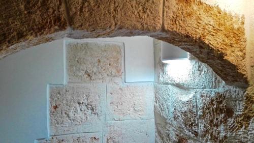 a room with a stone wall and a window at La Torre e il Mare Rooms by STHEY in Monopoli