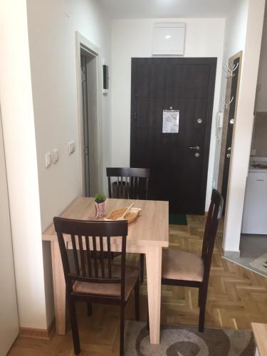 ein Esszimmer mit einem Holztisch und Stühlen in der Unterkunft DZL - Apartman Nina in Vrnjačka Banja