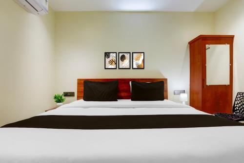 a bedroom with a large white bed with two pillows at Hotel O Ananthpur Formerly TR Residency in Anantapur