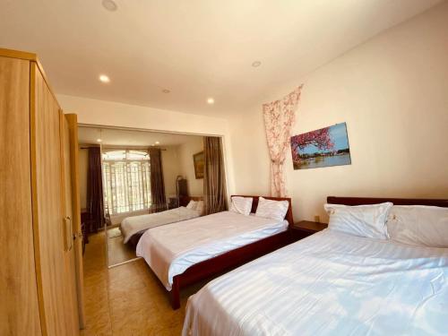a hotel room with two beds and a window at Tiên Hoa Sơn Villa in Da Lat