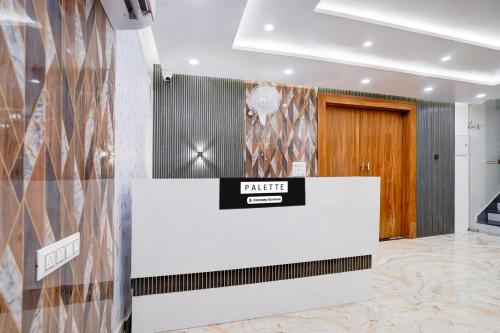 a lobby with a white counter with a sign on it at Palette Hotel and Resort Sarnath Temple in Varanasi