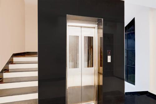 a hallway with a glass door next to a staircase at Palette Hotel and Resort Sarnath Temple in Varanasi