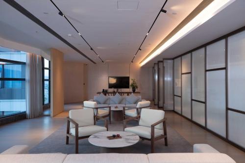 a living room with a table and chairs at PERNULO Hotel Fuzhou in Fuzhou