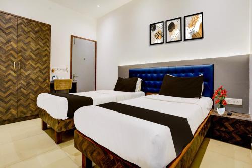 a hotel room with two beds in a room at Super Collection O Sanpada Railway Junction in Turambhe