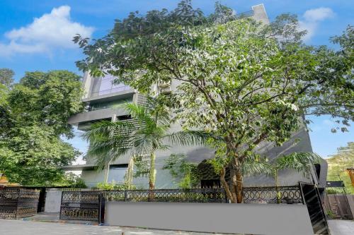 a building with a tree in front of it at Super Collection O Sanpada Railway Junction in Turambhe
