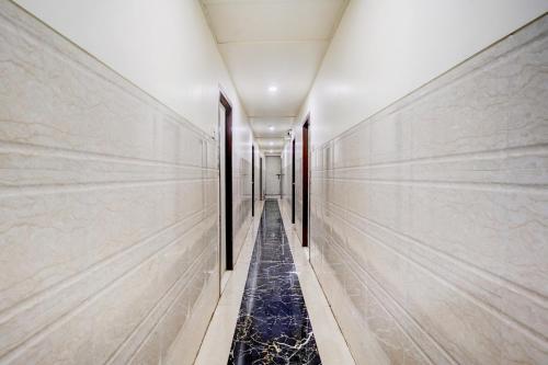 a corridor of a building with marble walls and a long hallway at Super Collection O Ulhasnagar Railway Station Formerly Hotel Derby in Kalyan