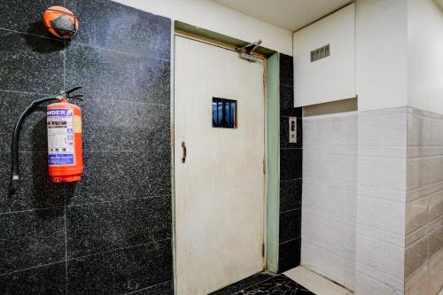 a bathroom with a fire extinguisher next to a door at Super Collection O Ulhasnagar Railway Station Formerly Hotel Derby in Kalyan